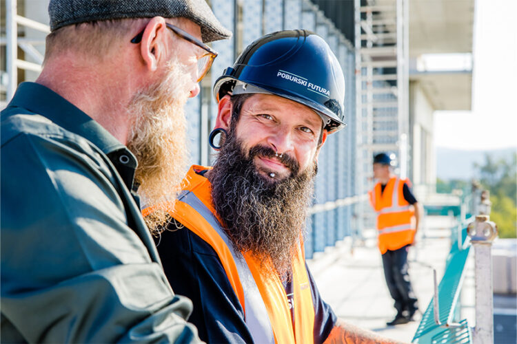 Zwei Bauleiter besprechen Details auf einer Flachdachbaustelle