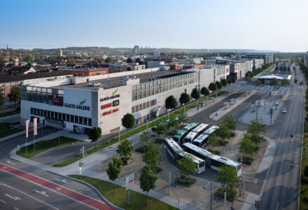 In der Nähe des Neu-Ulmer Bahnhofs gelegen, besticht das innerstädtische Einkaufszentrum durch seine anspruchsvolle Parkdachlösung und bietet 1.100 Stellplätze für Besucher und Pendler. Diese komplexe Geometrie stellte besondere Anforderungen an die Gefälleplanung, Entwässerung und die Ausführung des Plattenrasters der Betonfahrbahnplatten.