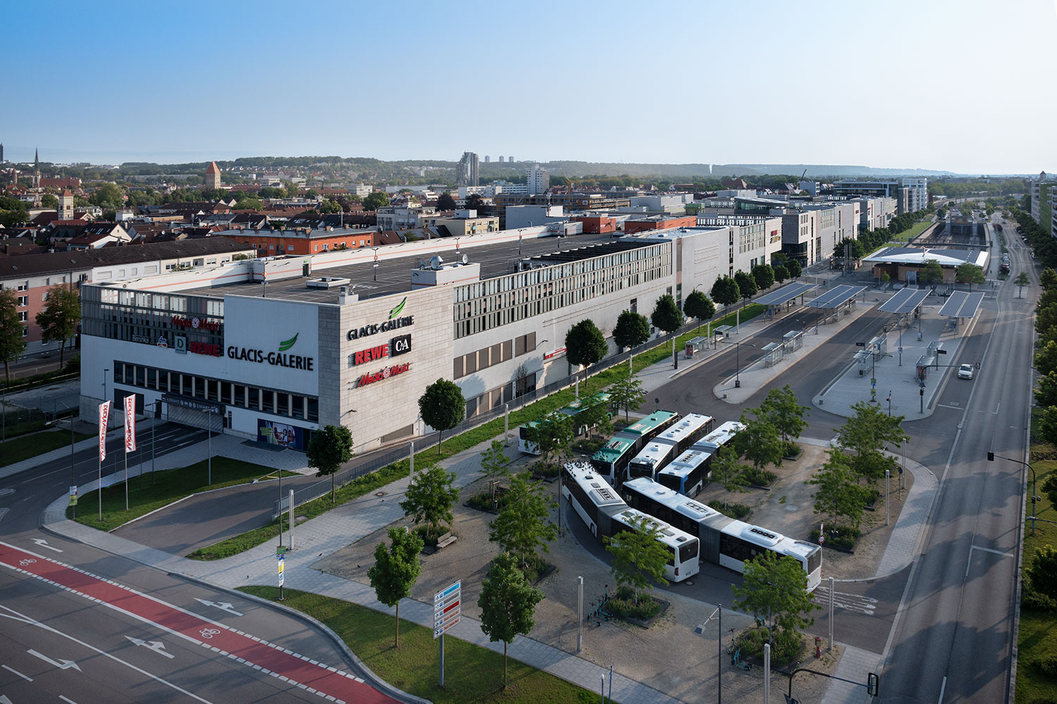 In der Nähe des Neu-Ulmer Bahnhofs gelegen, besticht das innerstädtische Einkaufszentrum durch seine anspruchsvolle Parkdachlösung und bietet 1.100 Stellplätze für Besucher und Pendler. Diese komplexe Geometrie stellte besondere Anforderungen an die Gefälleplanung, Entwässerung und die Ausführung des Plattenrasters der Betonfahrbahnplatten.